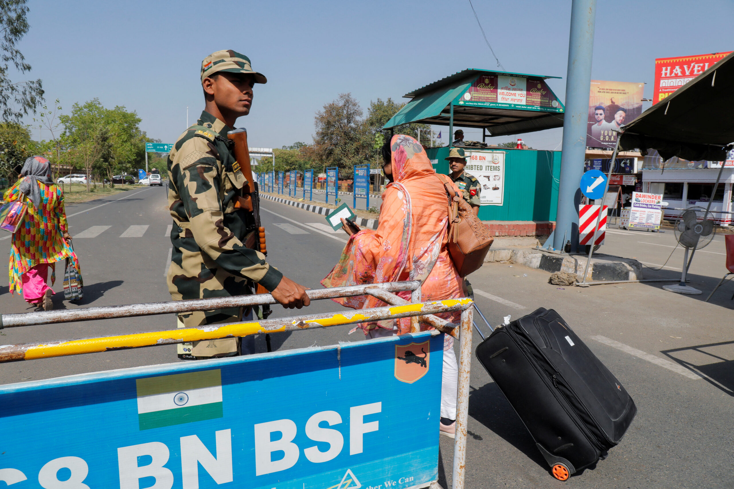 People carry baggage as they cross a Border Security checkpoint at the Attari-Wagah border crossing on the India-Pakistan border, near Amritsar